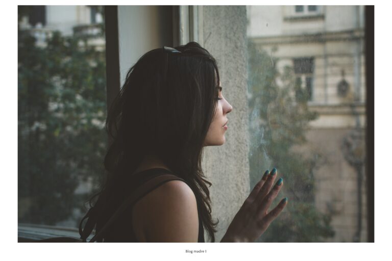 terapia, Mujer mirando por la ventana con expresión reflexiva, representando el ciclo del autosabotaje.